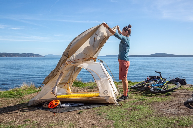 Setting up the big agnes tiger wall bikepack tent next to some water