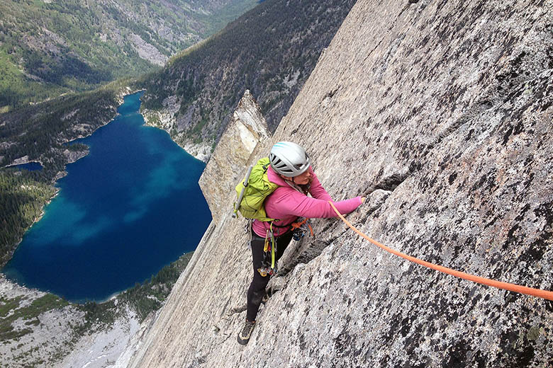 A women following a climbing route while wearing a climbing backpack