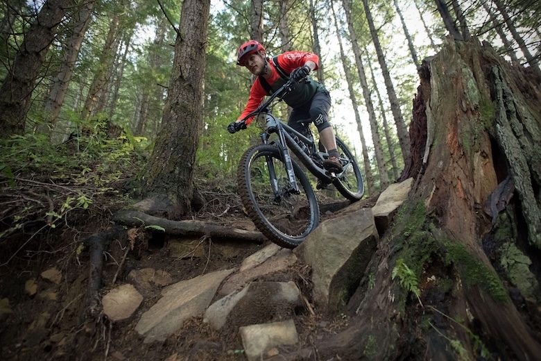 The Santa Cruz Bronson mountain bike coming downhill over some rocks