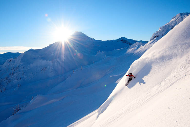 A splitboarder making a turn in powder in the backcountry