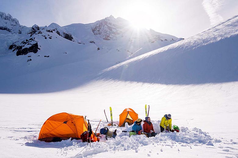 A snowy winter camp is set up high in the mountains.