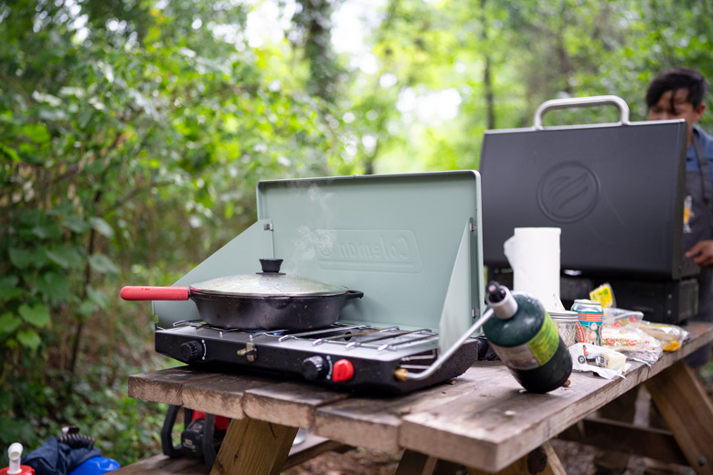 A camping stove sits on a picnic table in the woods of Tennessee