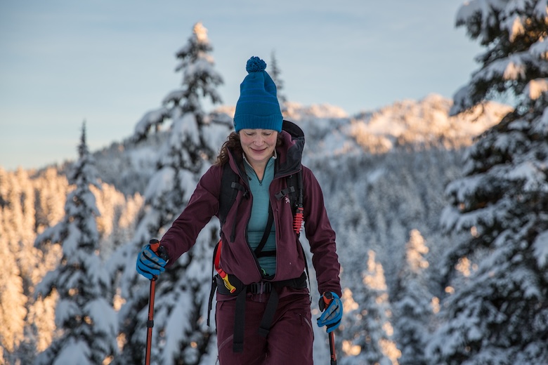 A woman on skis skins up a hill toward the camera