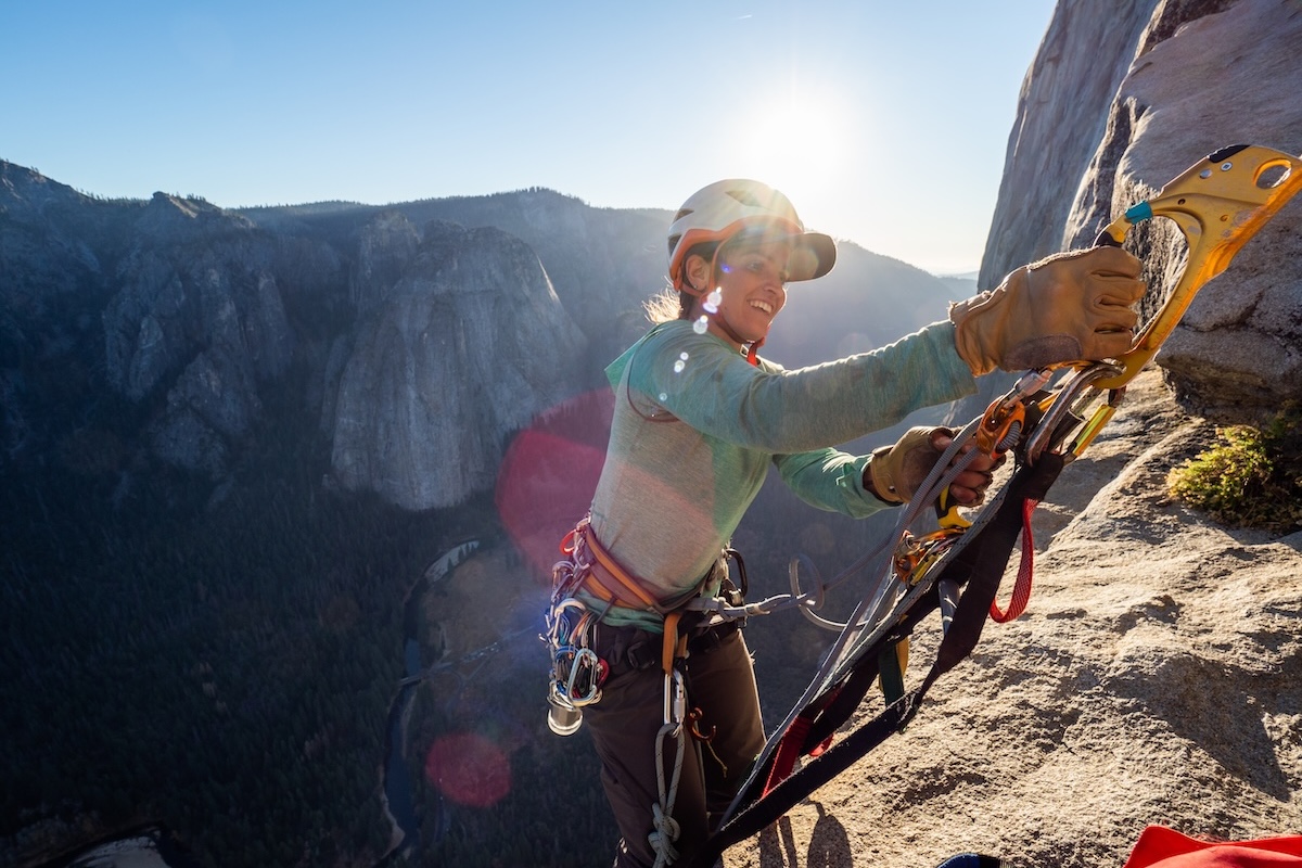 A women topping out on the rock climbing route Zodiac