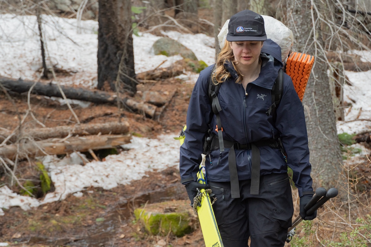 A woman carrying a full pack while out on a backpacking trip.