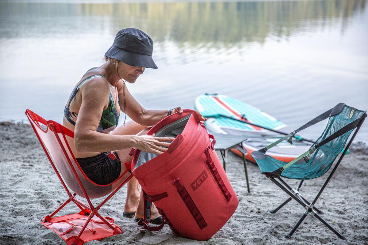 A woman unpacks her Yeti Hopper cooler after paddleboarding.