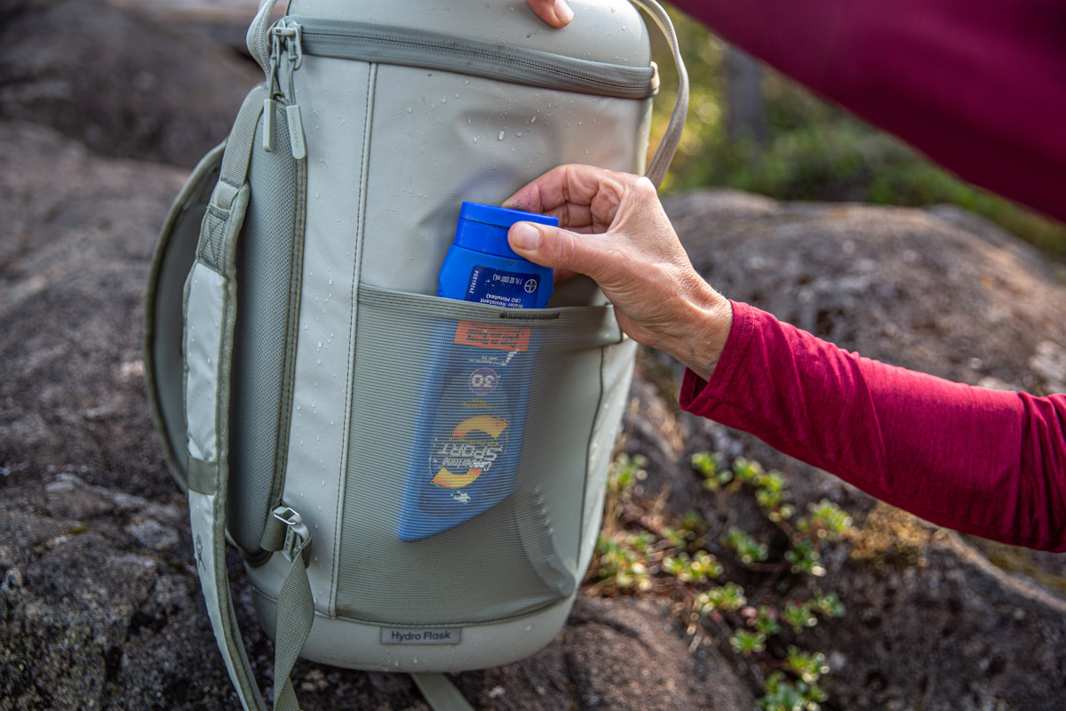 Putting sunscreen in a side mesh pocket on a backpack cooler