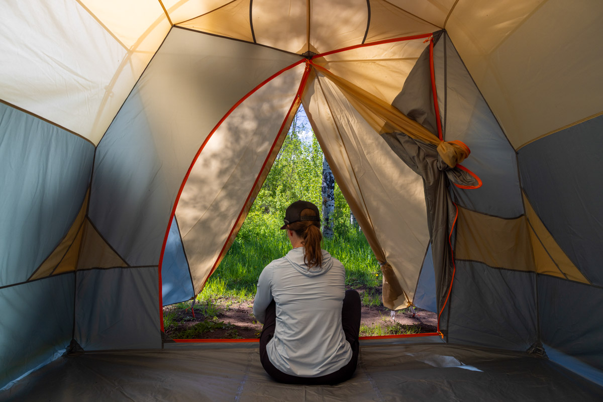 A woman sitting in a big camping tent.