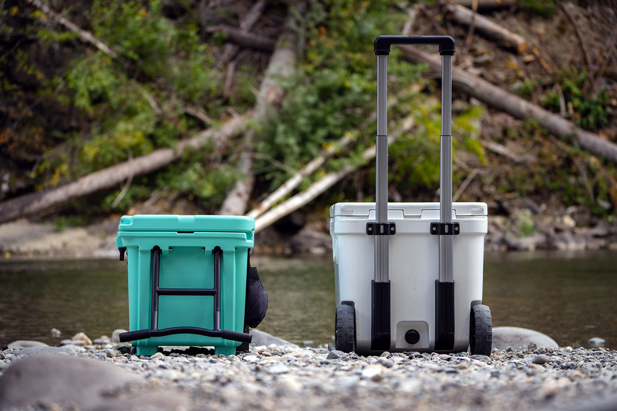 Two coolers with different types of handles - rigid and telescoping - are pictured side by side.