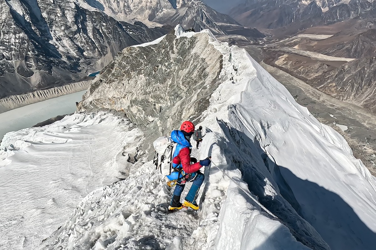 A mountaineer descends from a high mountain range. 