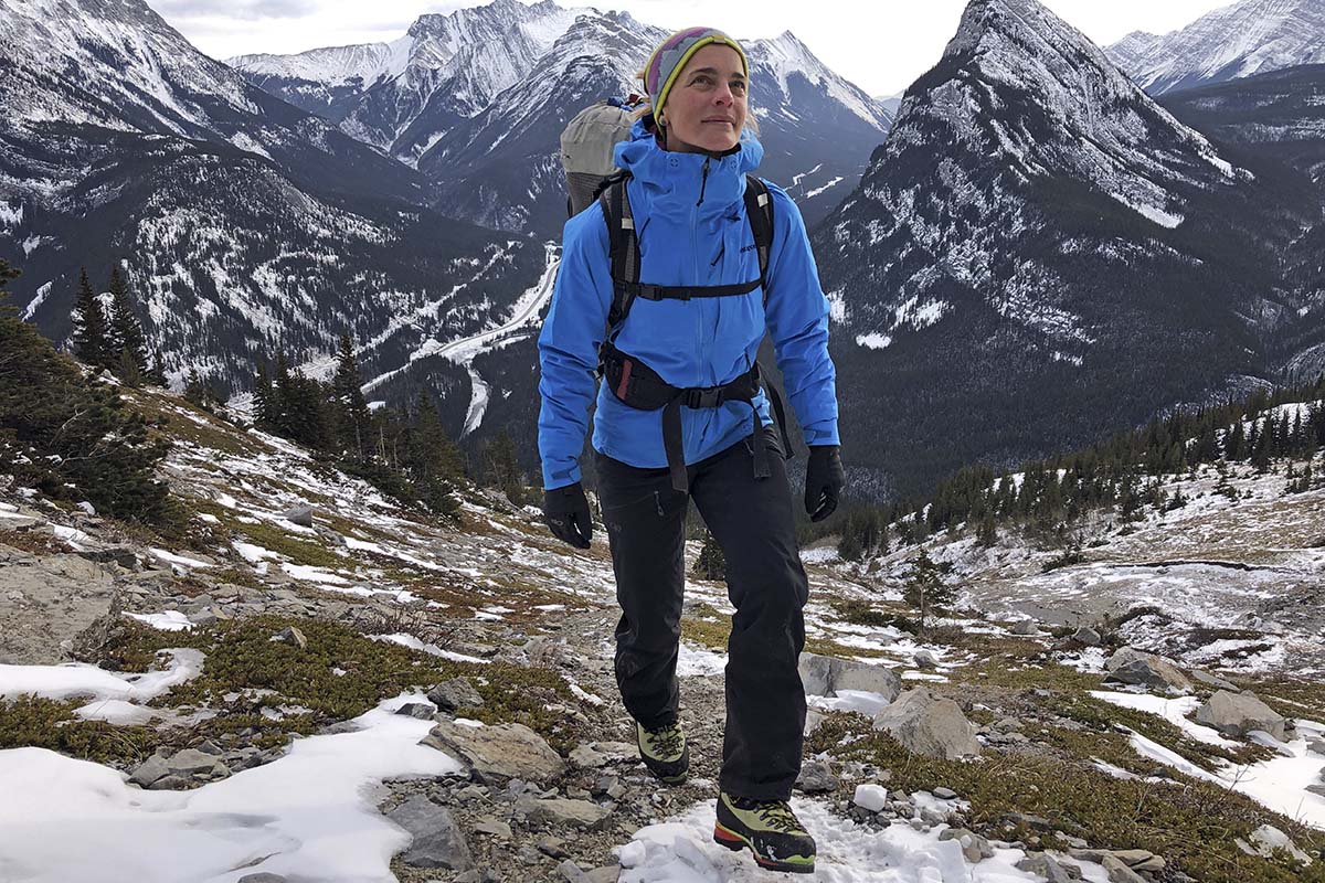 A mountaineer is walking through a stunning vista of snow covered peaks.