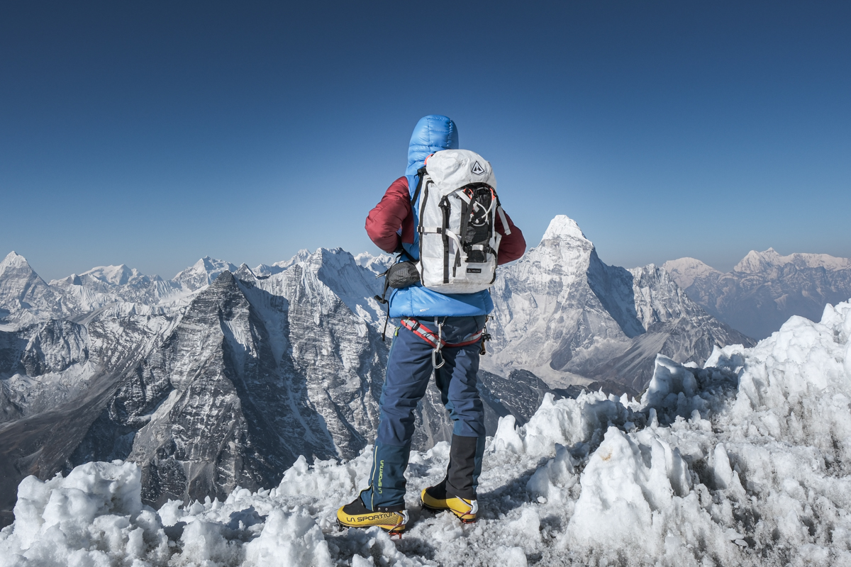 A mountaineer gazes out over the ice covered peaks in Nepal