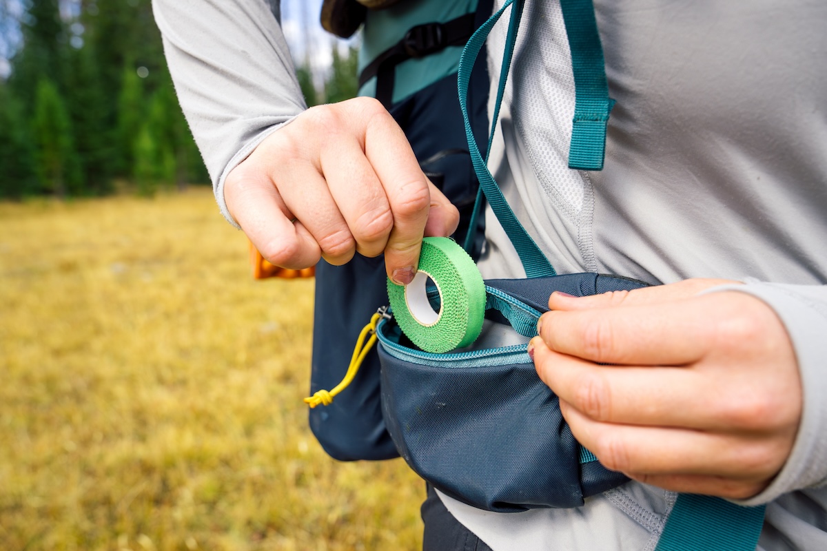 A woman putting tape in a hipbelt pocket