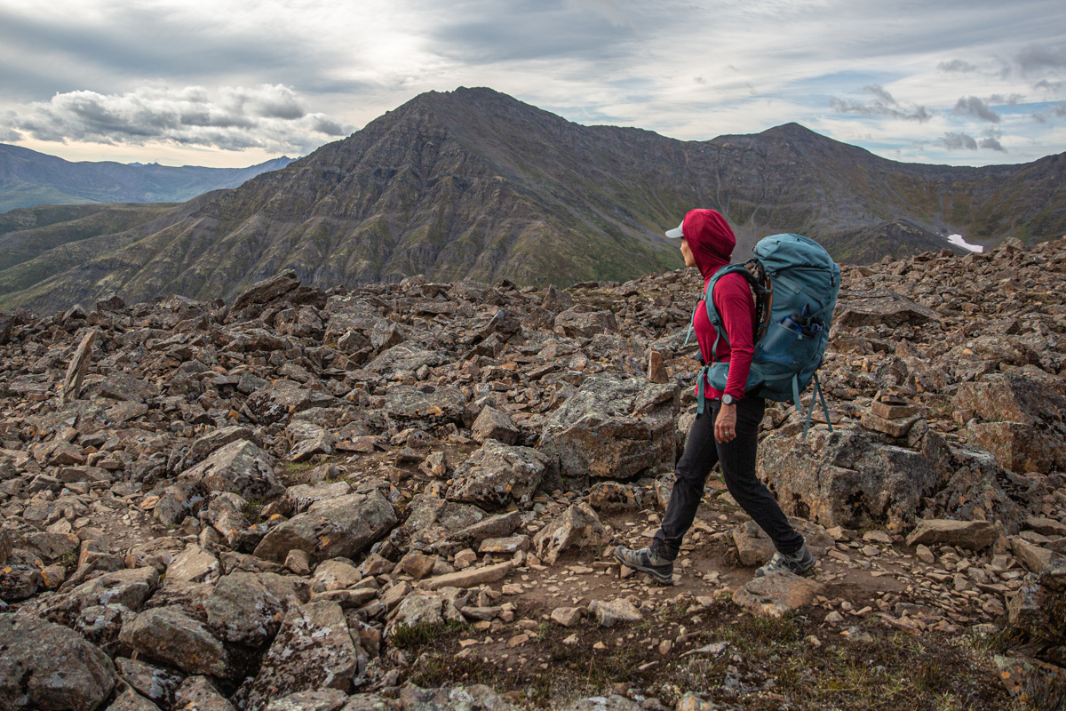 A woman hiking across a rocky trail wearing a fitness watch