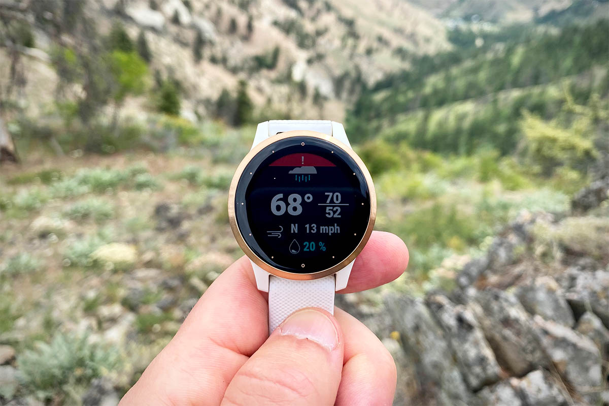 Holding up a fitness watch with weather information