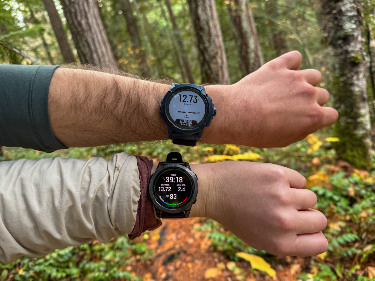 Two wrists displaying two different fitness watches