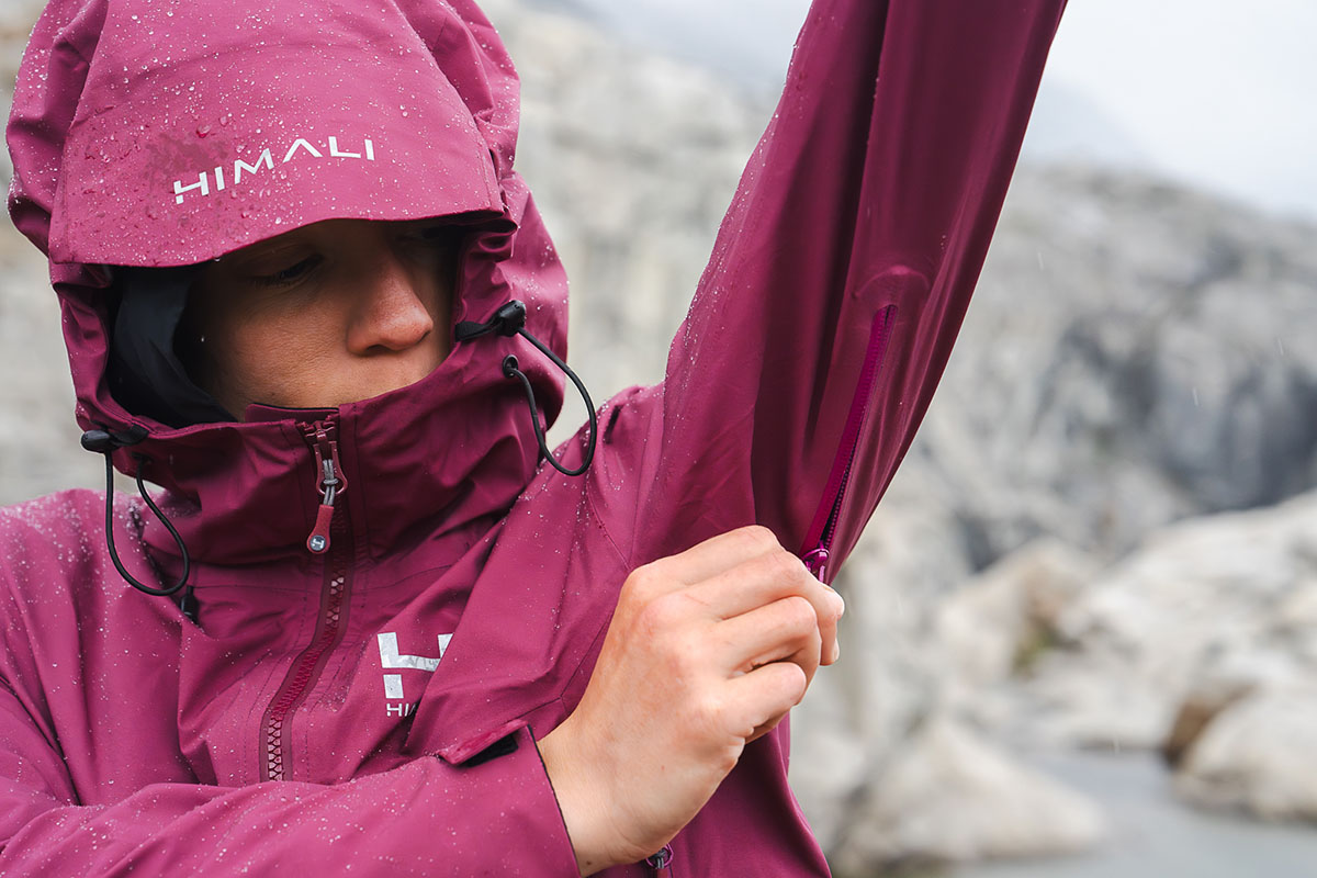 A woman unzips pit zips on the Himali Monsoon jacket