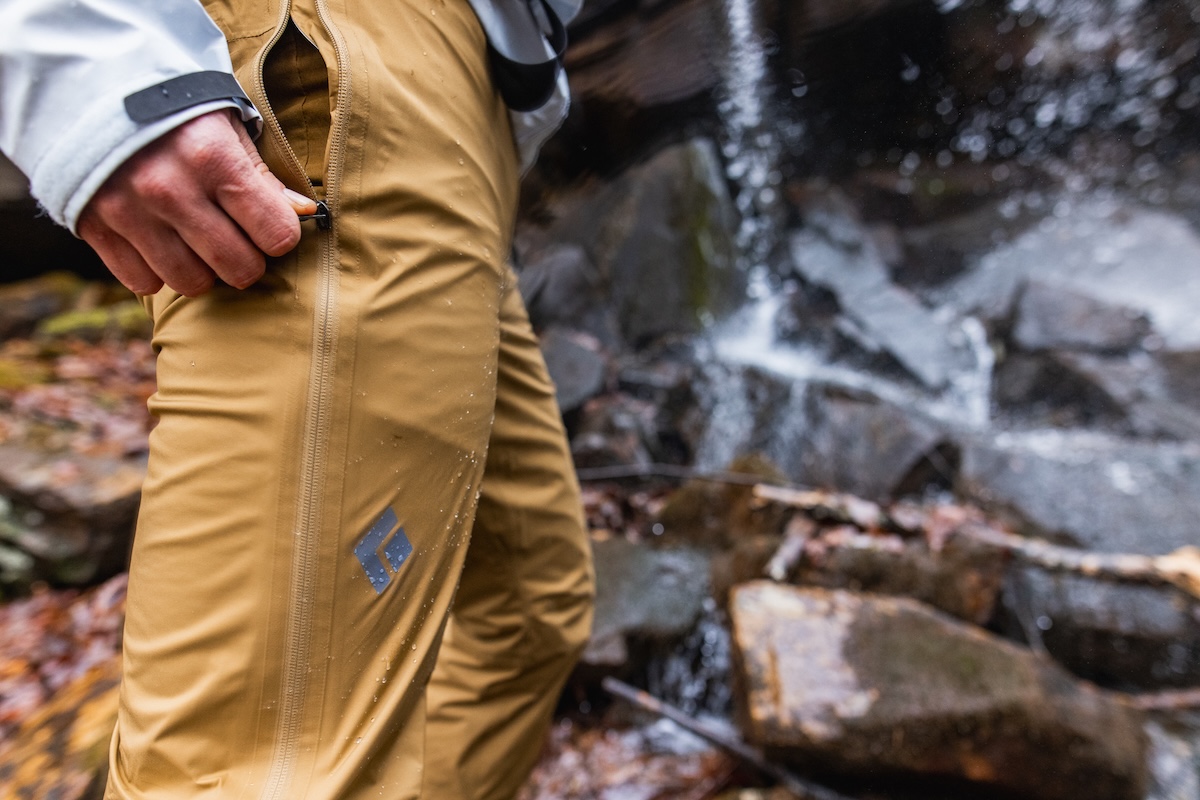 Unzipping a pair of full zip rain pants