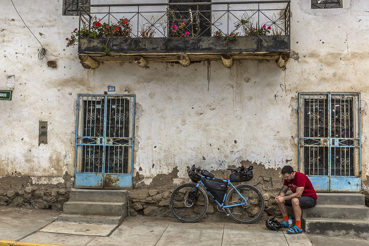 A man sits next to his bicycle in the Cordillera Blanca village