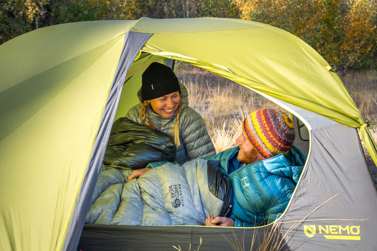 A couple creates a cozy sleeping bag nest in a backpacking tent.