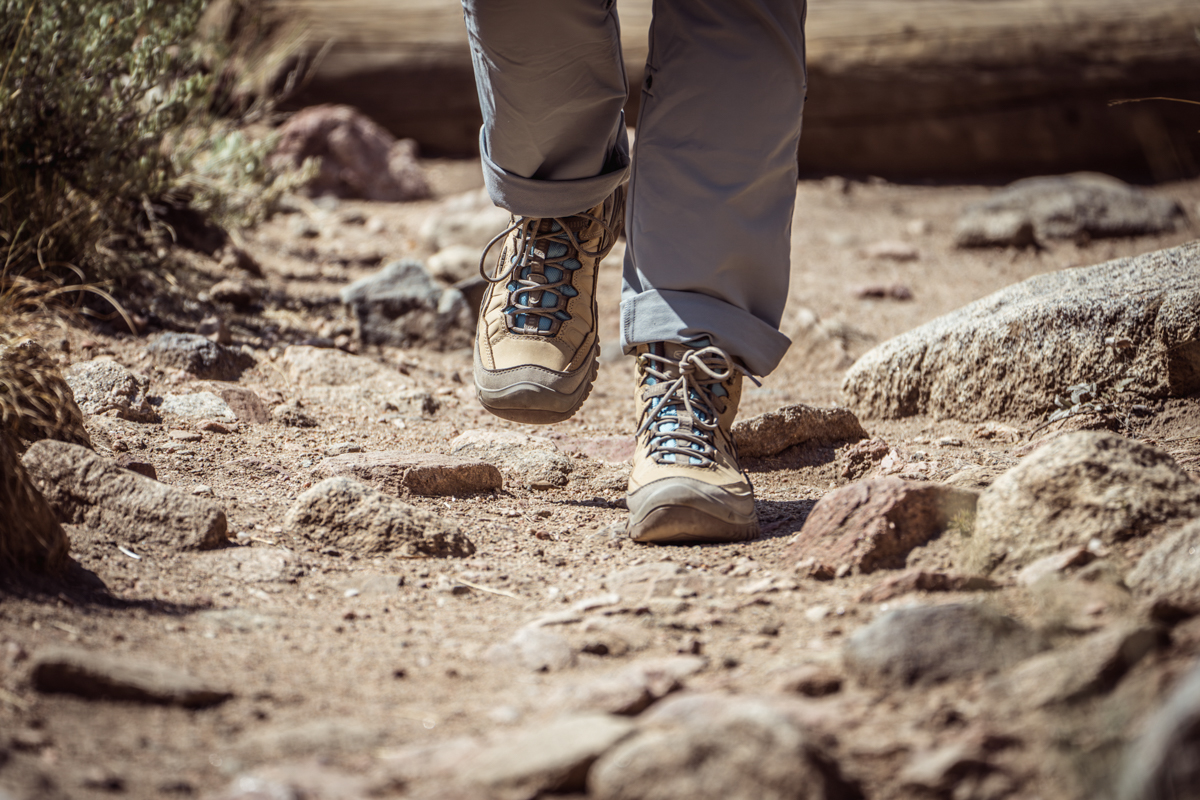 A hiker on a dirty, dusty trail makes way.