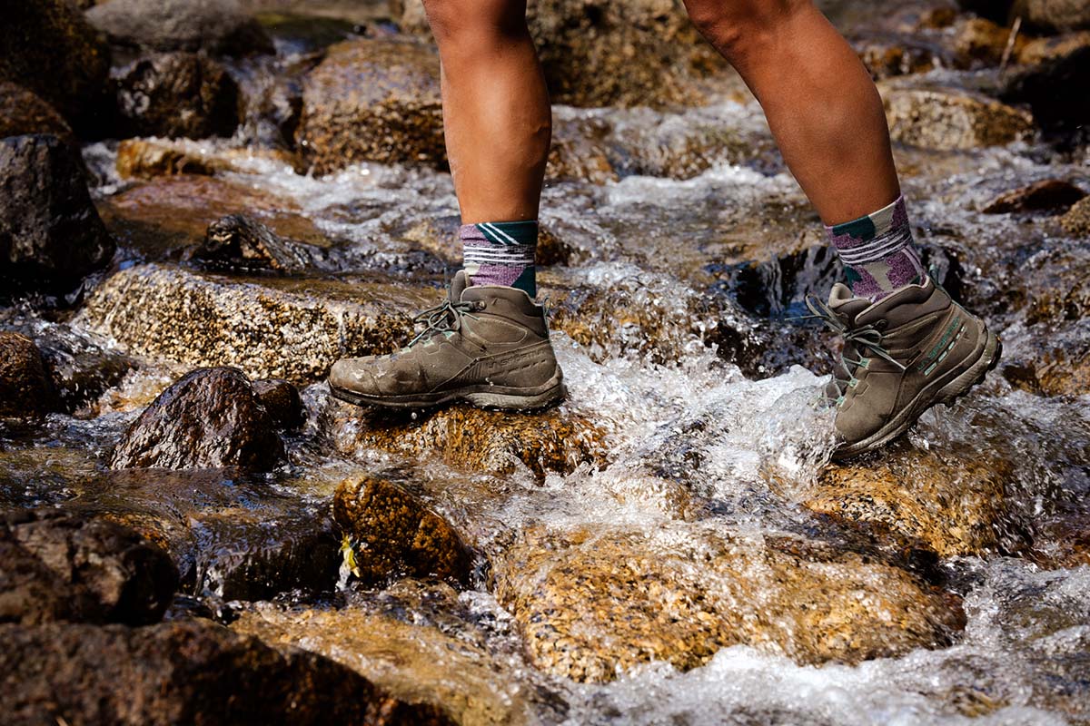 Crossing a stream in a pair of grey hiking boots