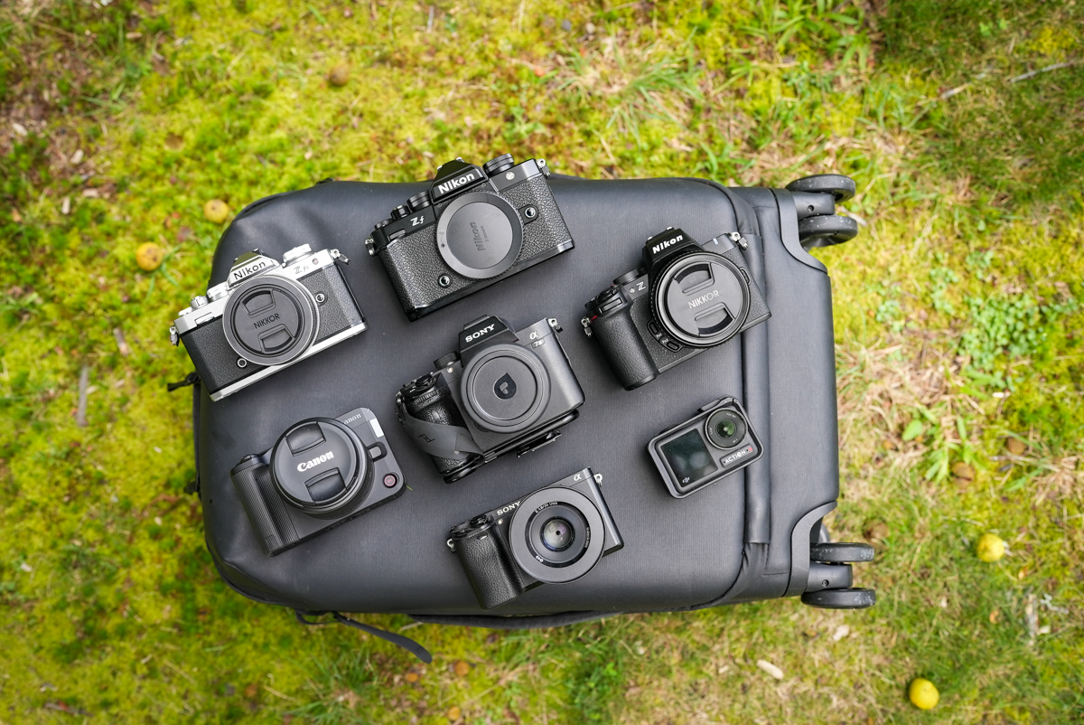 Several cameras lined up on a carry-on