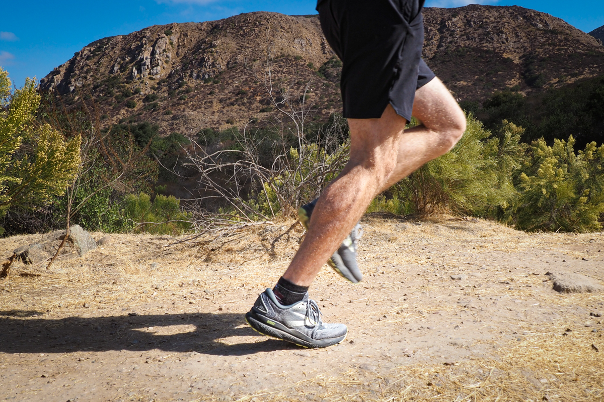 A shot of a man running in the Brooks Ghost 17 shoes on a dirt trail
