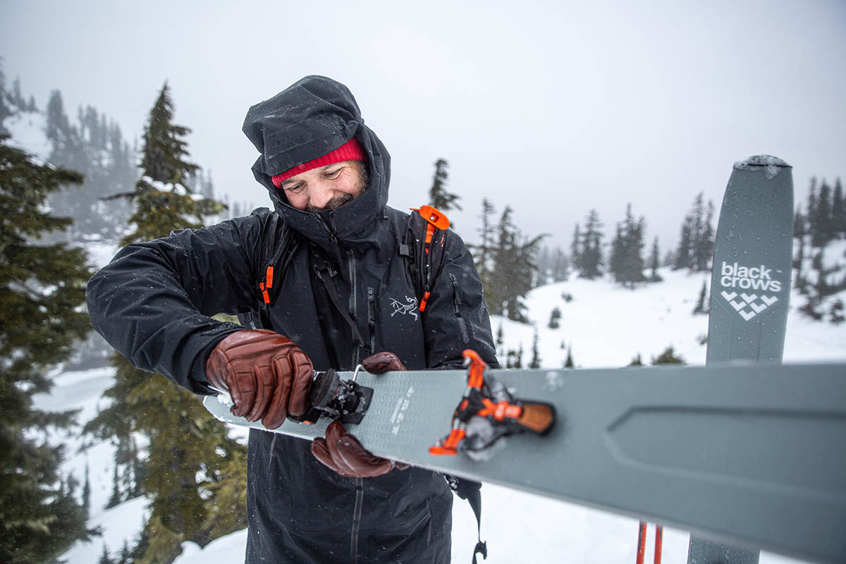 A skier adjusting the heel piece of some backcountry bindings