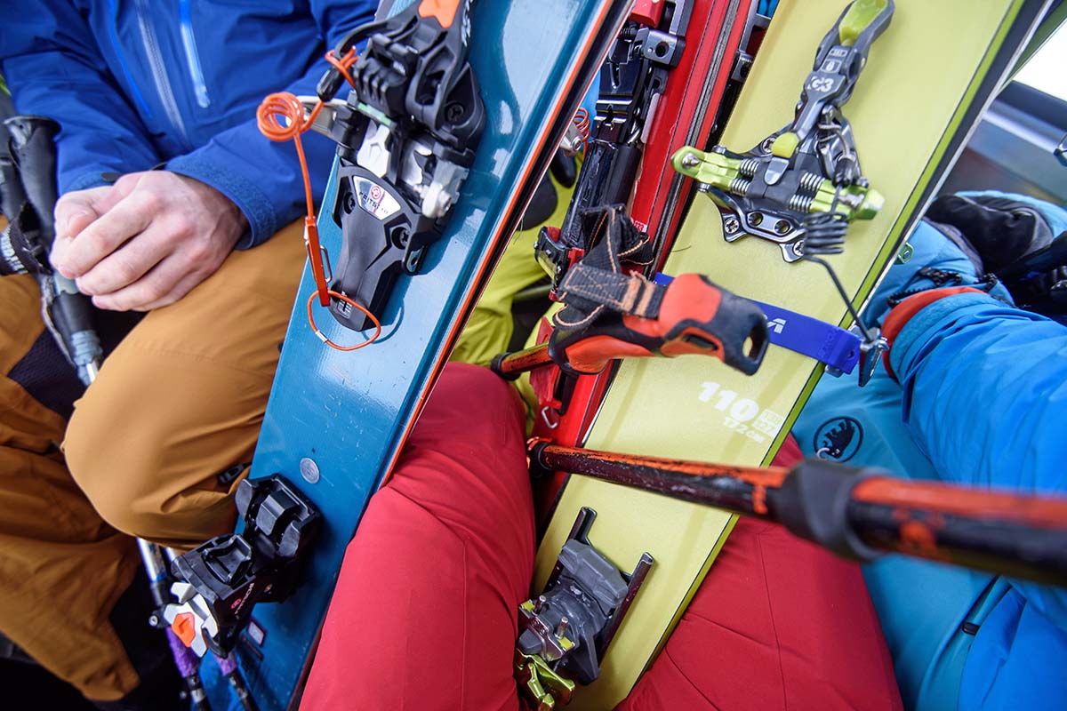 Several skiers in a tram with skis