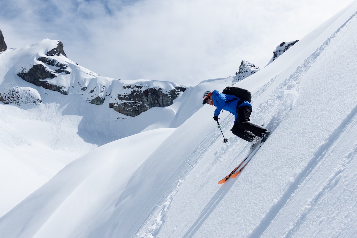 A skier making a powder turn on backcountry skis