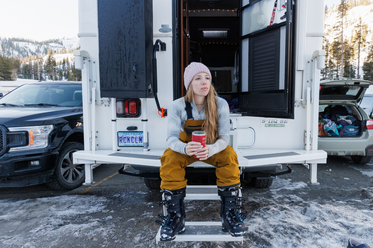 A woman relaxing in the Smartwool Classic Thermal Merino Quarter zip baselayer while sitting on a truck bed