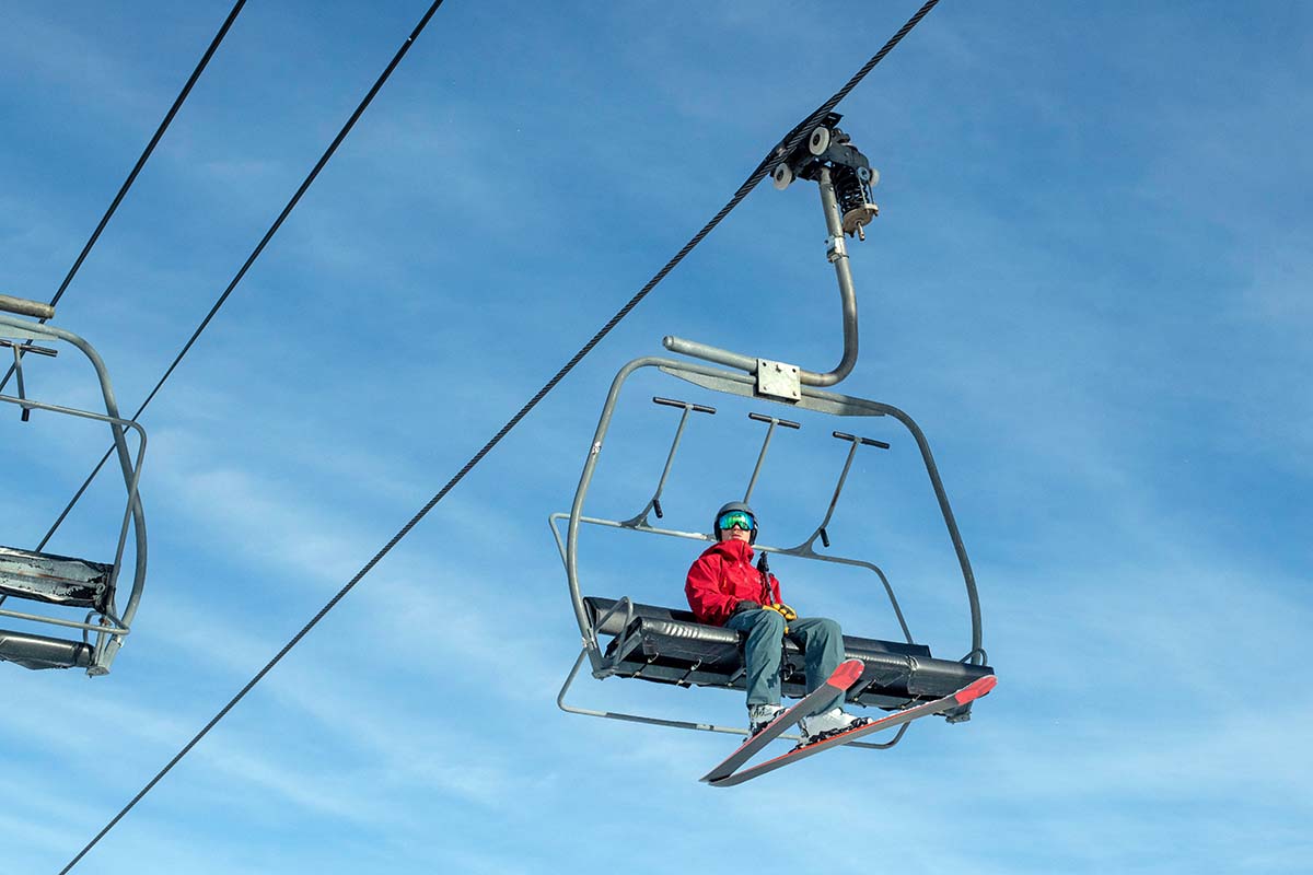 A skier rides a chairlift