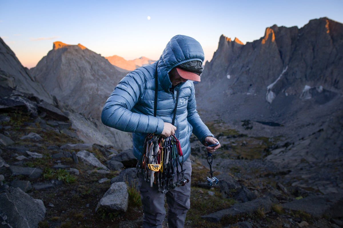 A man racks up with climbing gear while wearing a down jacket 
