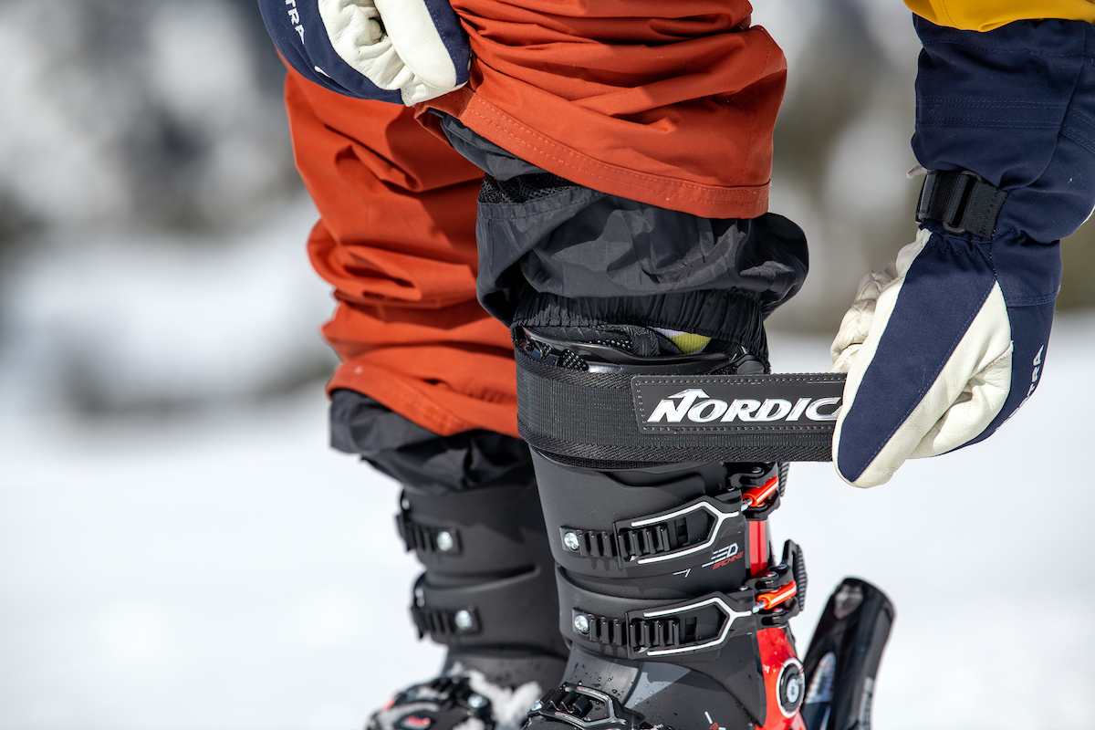 A skier adjusts the power strap, or top strip of velcro, on their boot.