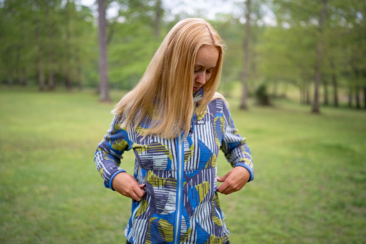 A woman wearing the REI Trailmade fleece on a rainy day