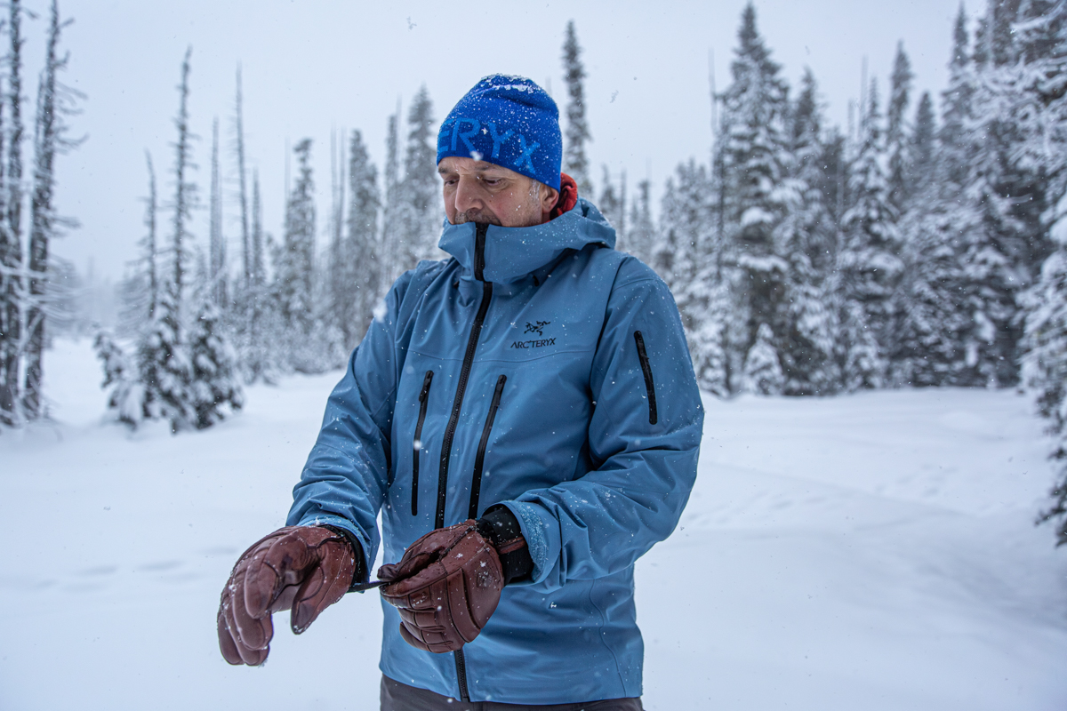 A man wearing the Arc'teryx Alpha SV in a snowstorm