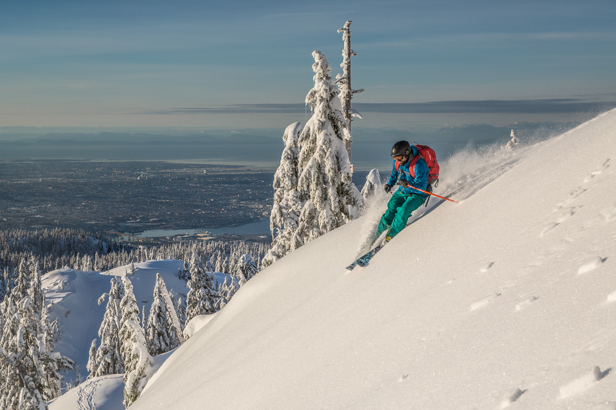 A skier makes a turn while coming down a steep slope in the backcountry