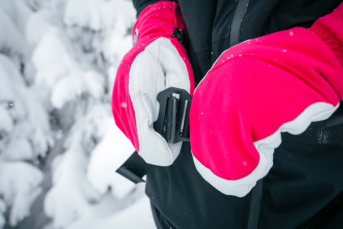 A person showing the metal buckles on a Black Diamond ski backpack waistband
