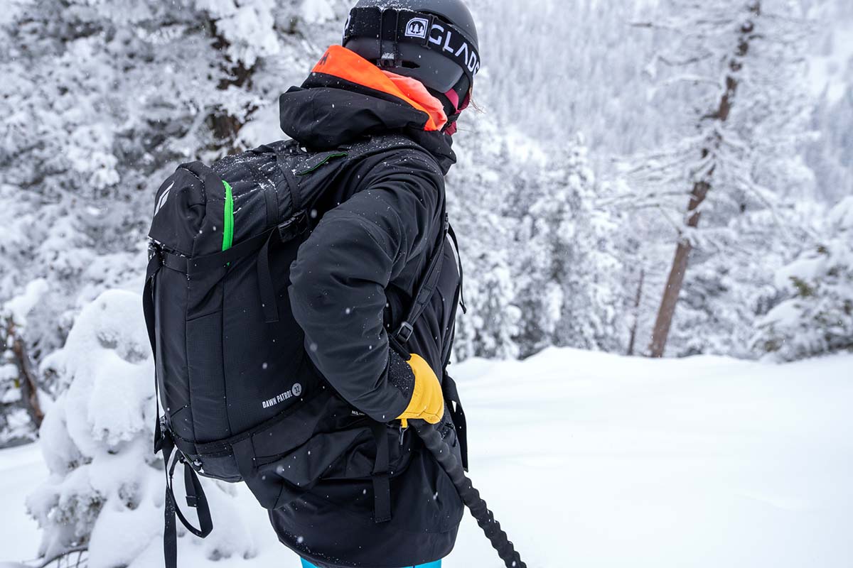 A skier looking down into a snowy valley while wearing a Black Diamond backpack