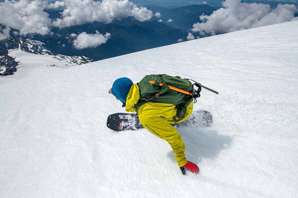 A snowboarder making a turn and showing that these backpacks are not just for skiers