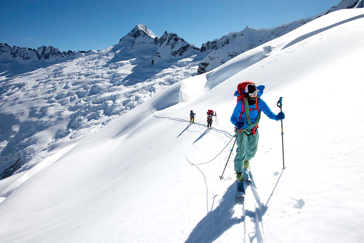 People ski touring up a glacier