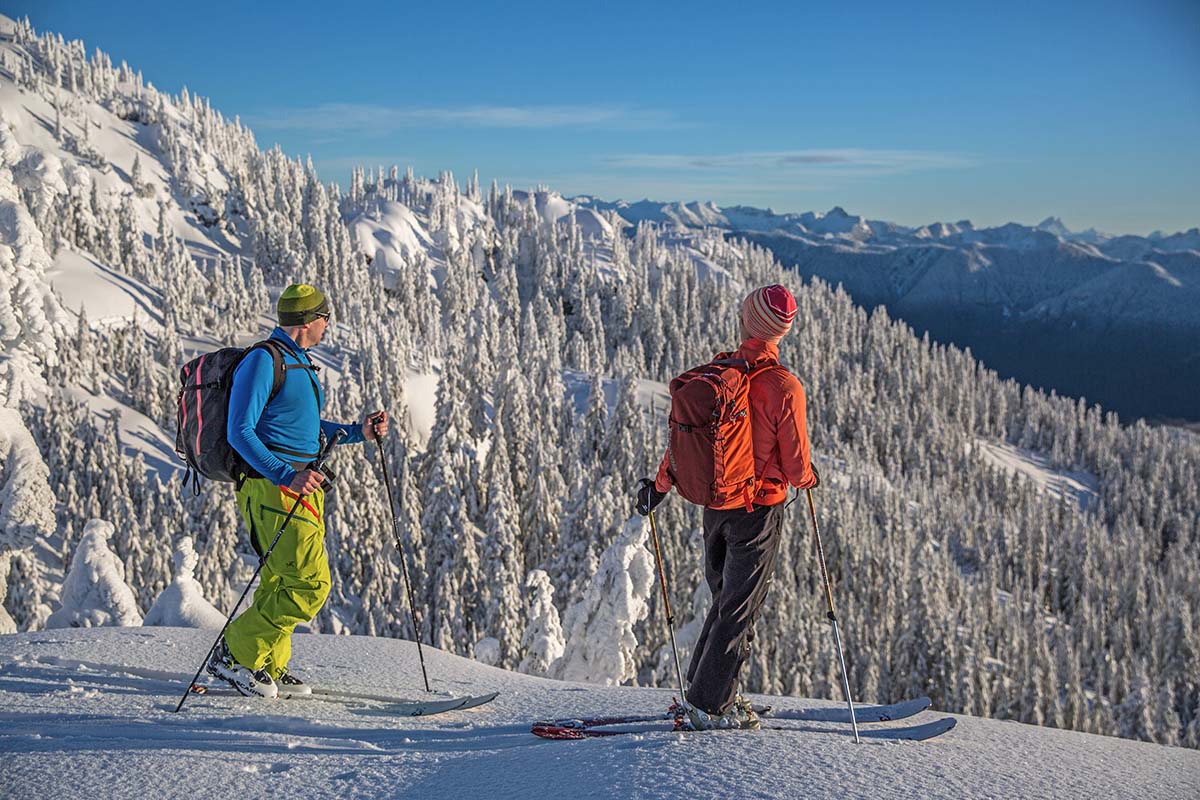 Two people looking out over a snowy mountain valley