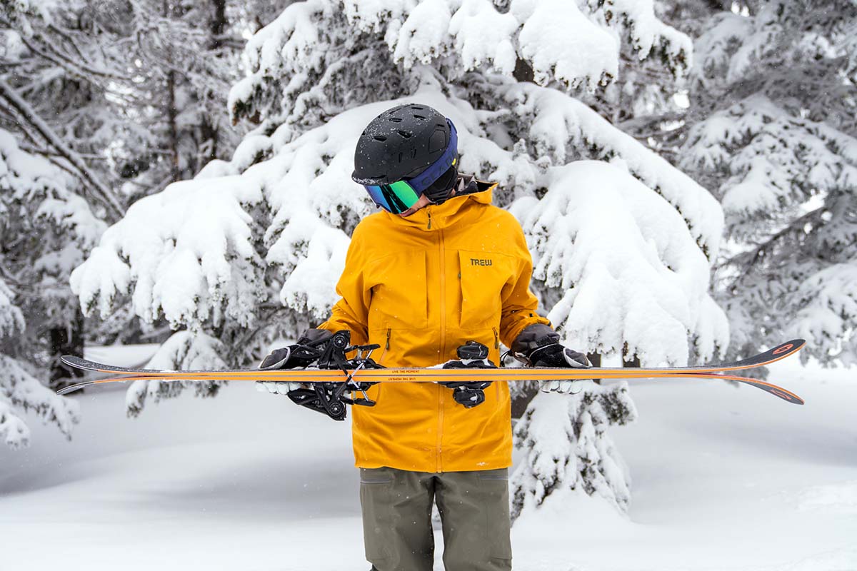 A skier holding up Rustler skis mounted with the Marker Griffon bindings