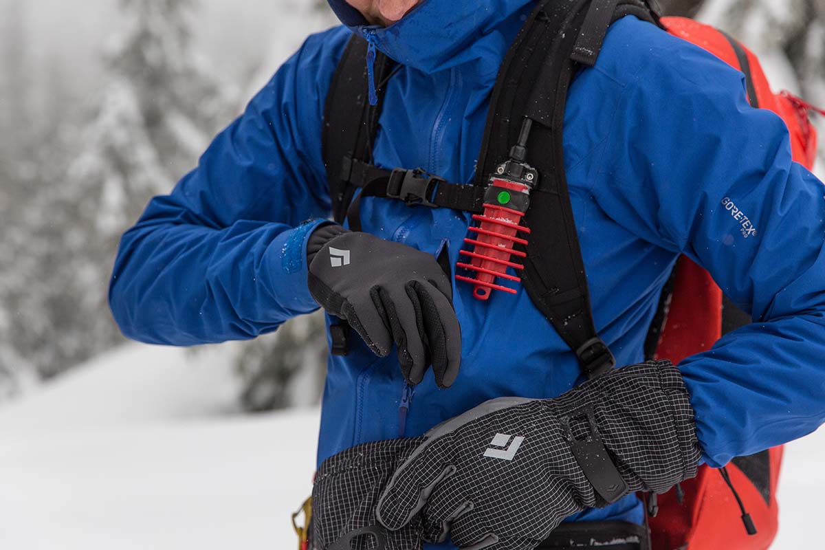 Reaching into pocket with liner of ski glove