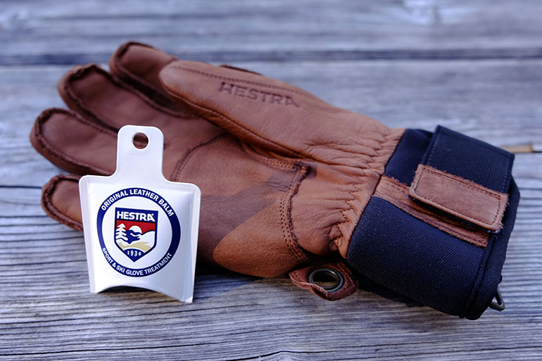A brown leather ski glove and leather balm