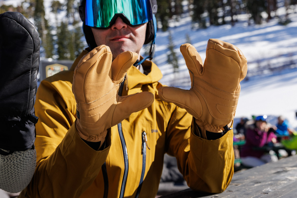 A man showing off palms of ski gloves