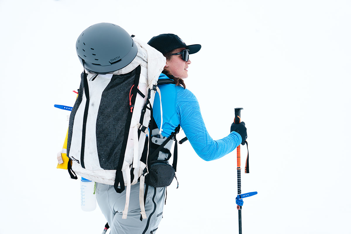 A ski helmet strapped to the back of a ski backpack