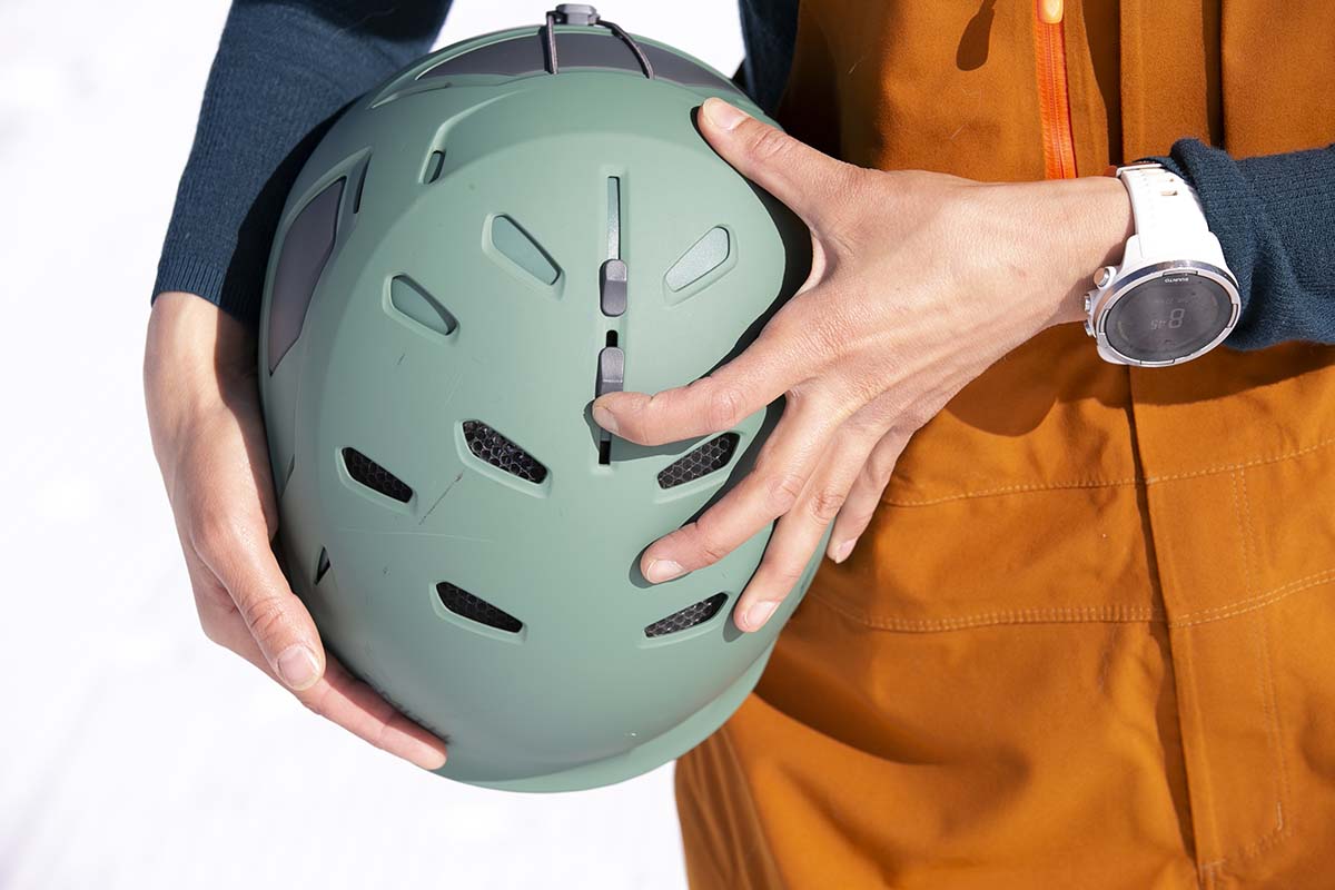 A close up of vent adjustments on the top of a ski helmet