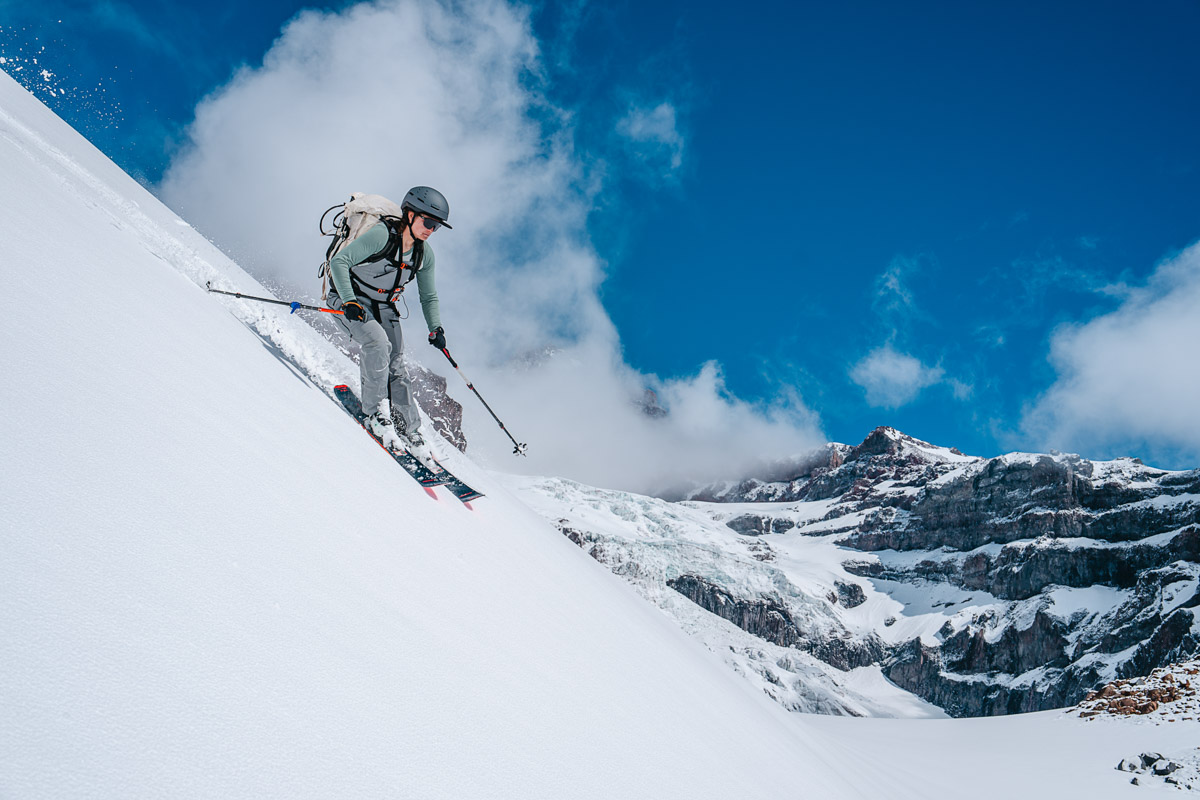 A woman skiing in the mountains wearing a ski helmet